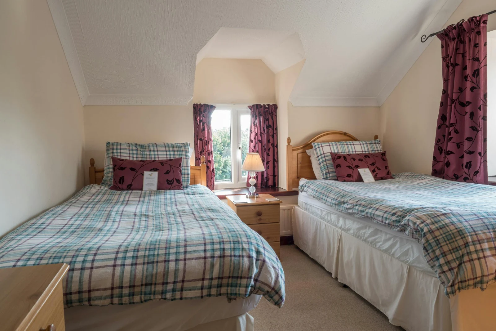 Twin single beds, bedside cabinet with a lamp, drawers and windows