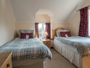 Twin single beds, bedside cabinet with a lamp, drawers and windows