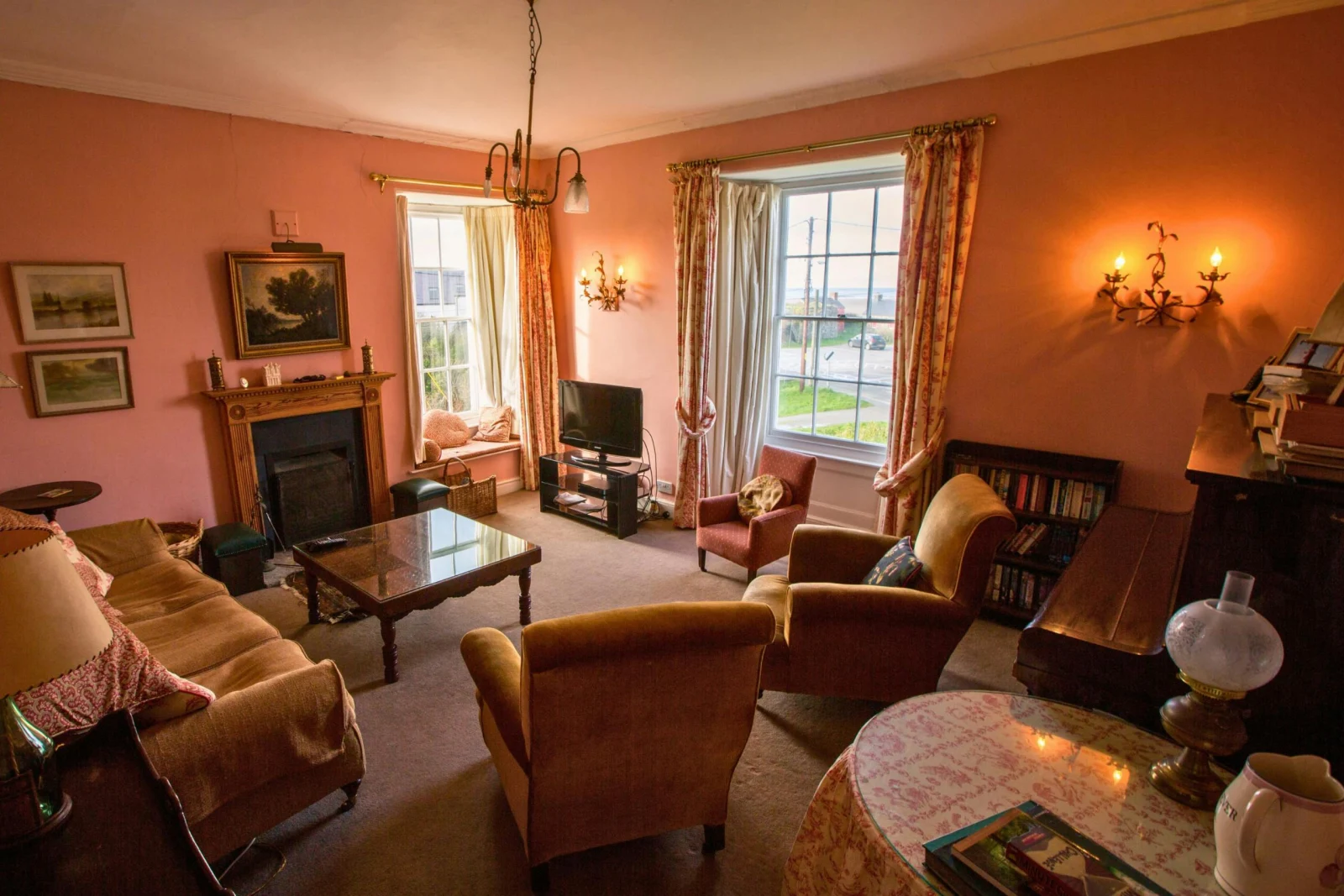 Drawing room: sofa, armchairs, coffee table, open fireplace, TV and piano