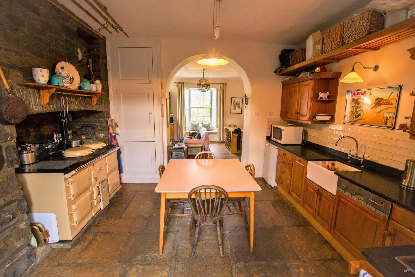Fitted kitchen with large aga cooker, microwave, kettle, butlers sink, table and four chairs
