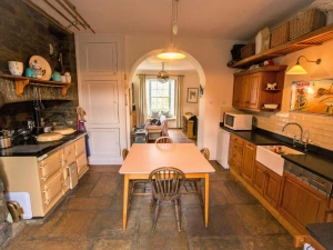 Fitted kitchen with large aga cooker, microwave, kettle, butlers sink, table and four chairs