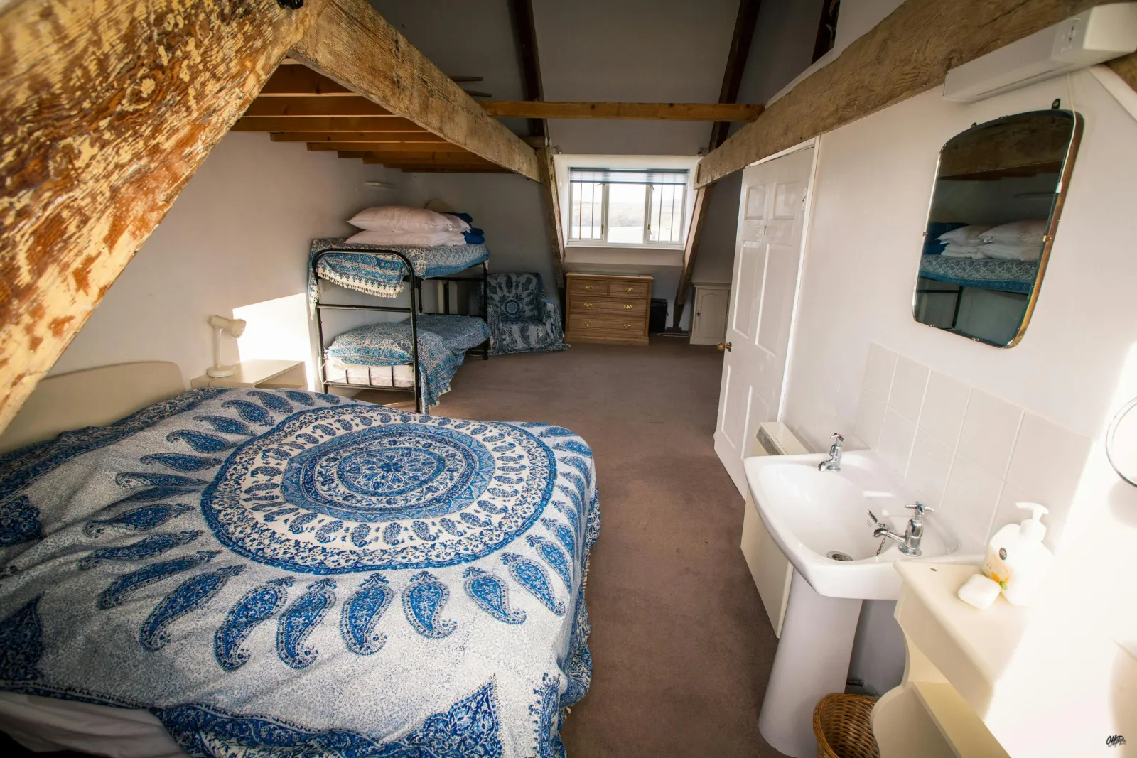 Double bed and bunk beds, bedside table with a lamp, chest of drawers and washbasin