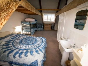 Double bed and bunk beds, bedside table with a lamp, chest of drawers and washbasin