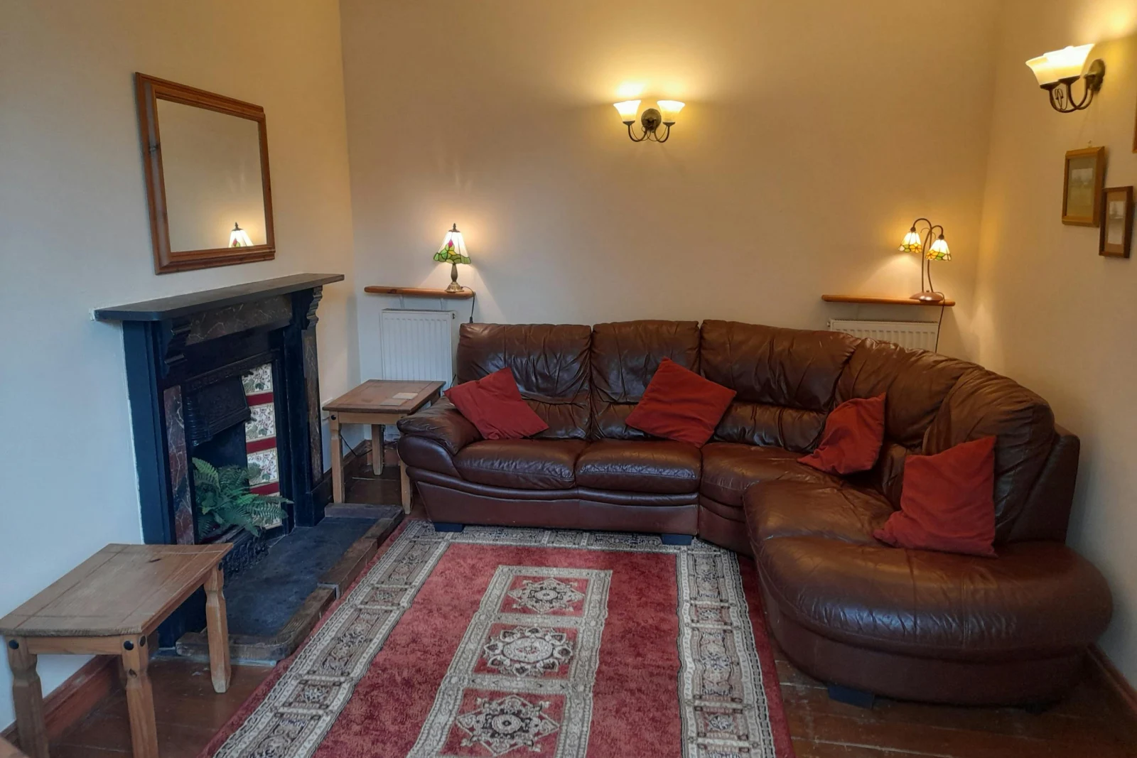 Lounge with open fire, coffee tables, leather corner sofa and armchair