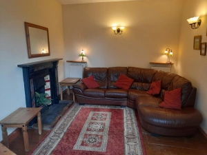 Lounge with open fire, coffee tables, leather corner sofa and armchair