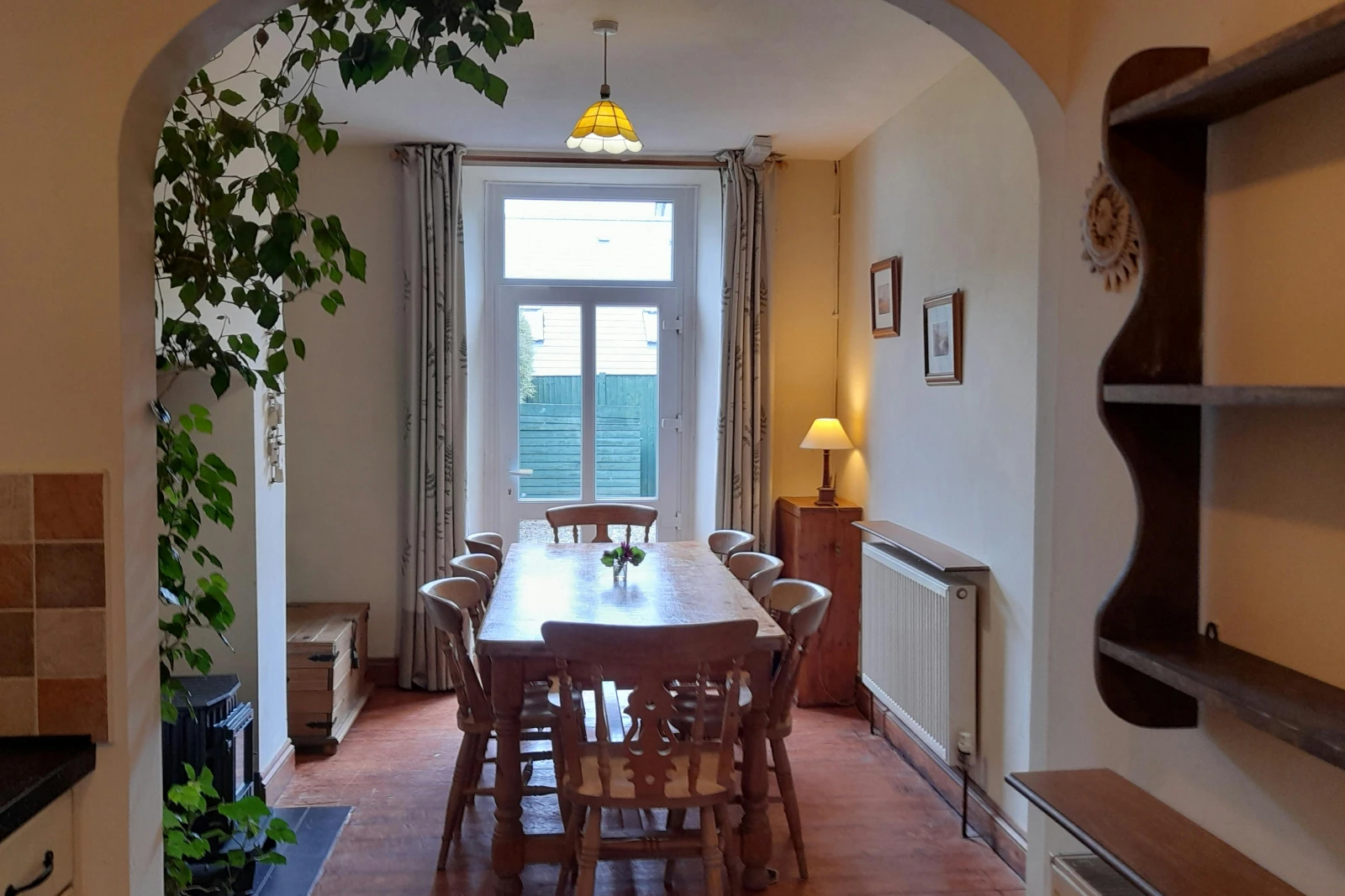 Wooden dining table seating nine. Door leading to the garden