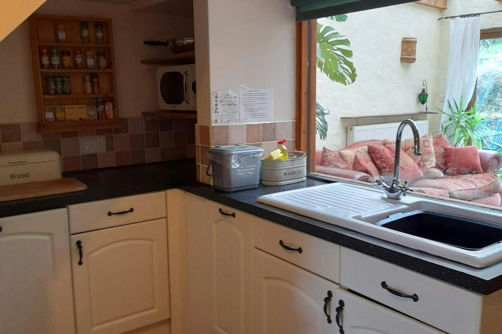 White base kitchen cupboards. Window looking into the conservatory