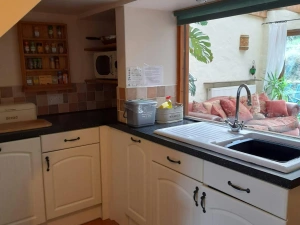 White base kitchen cupboards. Window looking into the conservatory
