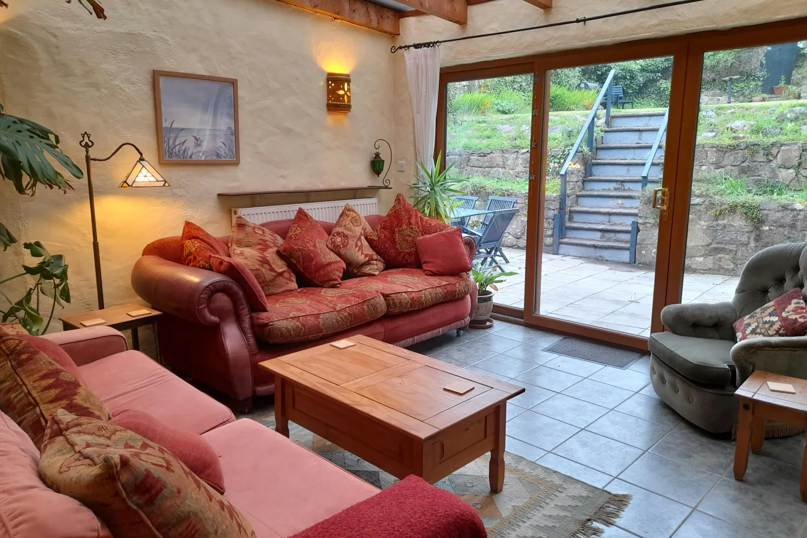 Second lounge: two sofas, armchair, coffee table, patio doors leading to outside