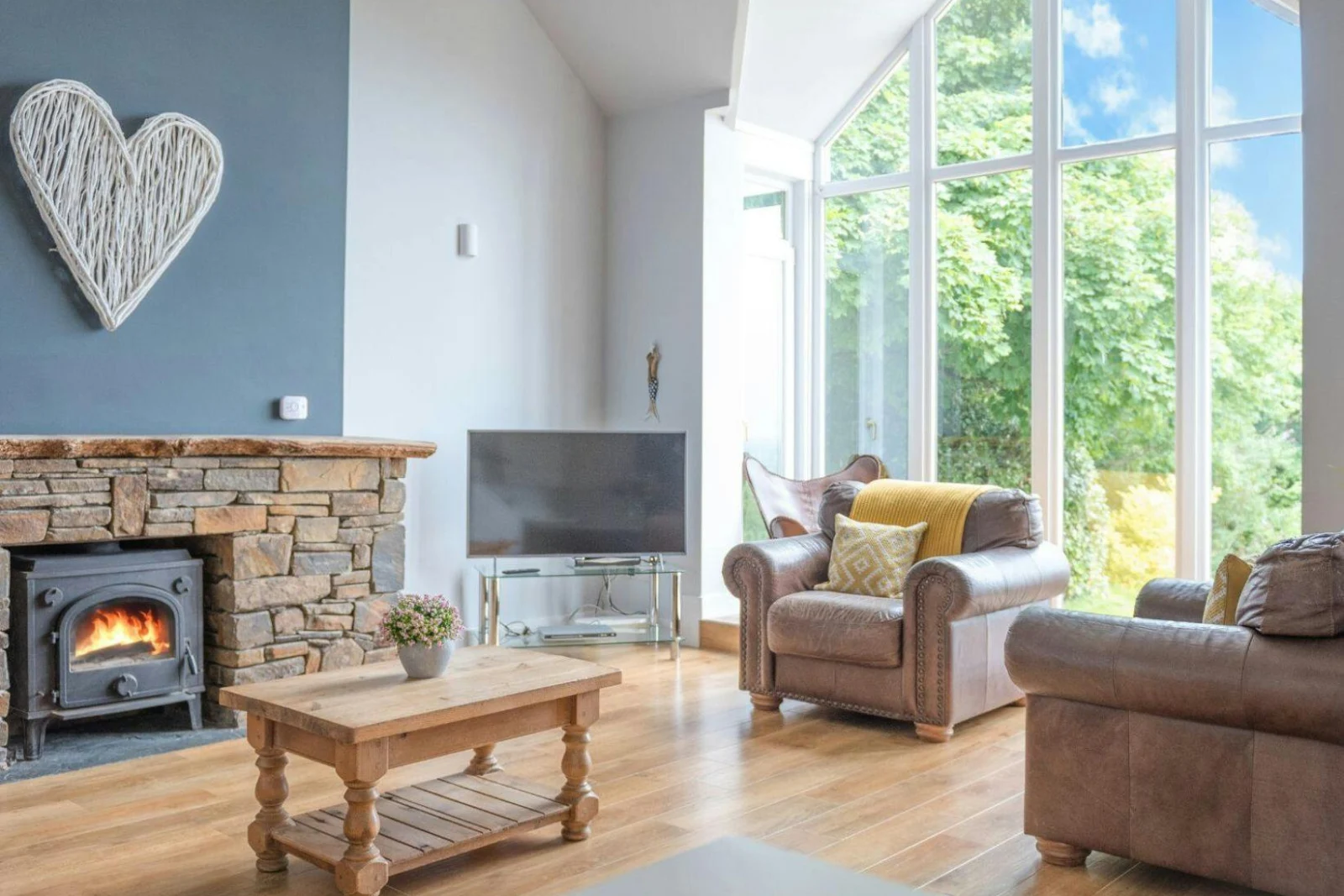 Lounge area with armchairs, coffee table, TV on stand and fireplace