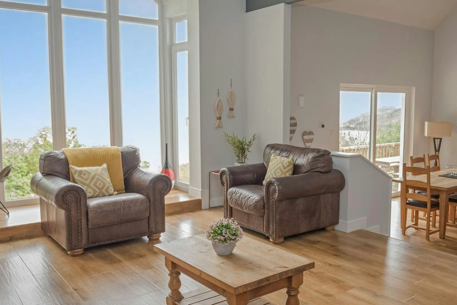 Lounge area with two armchairs and coffee table; dining area and breakfast bar