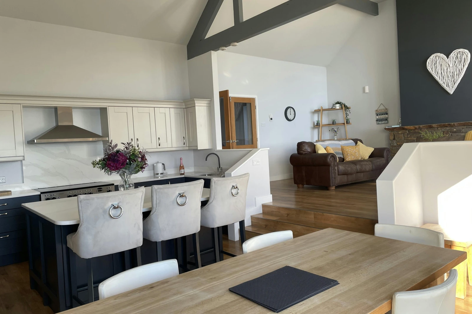 Open plan kitchen/diner, dining table, kitchen island with three bar stools
