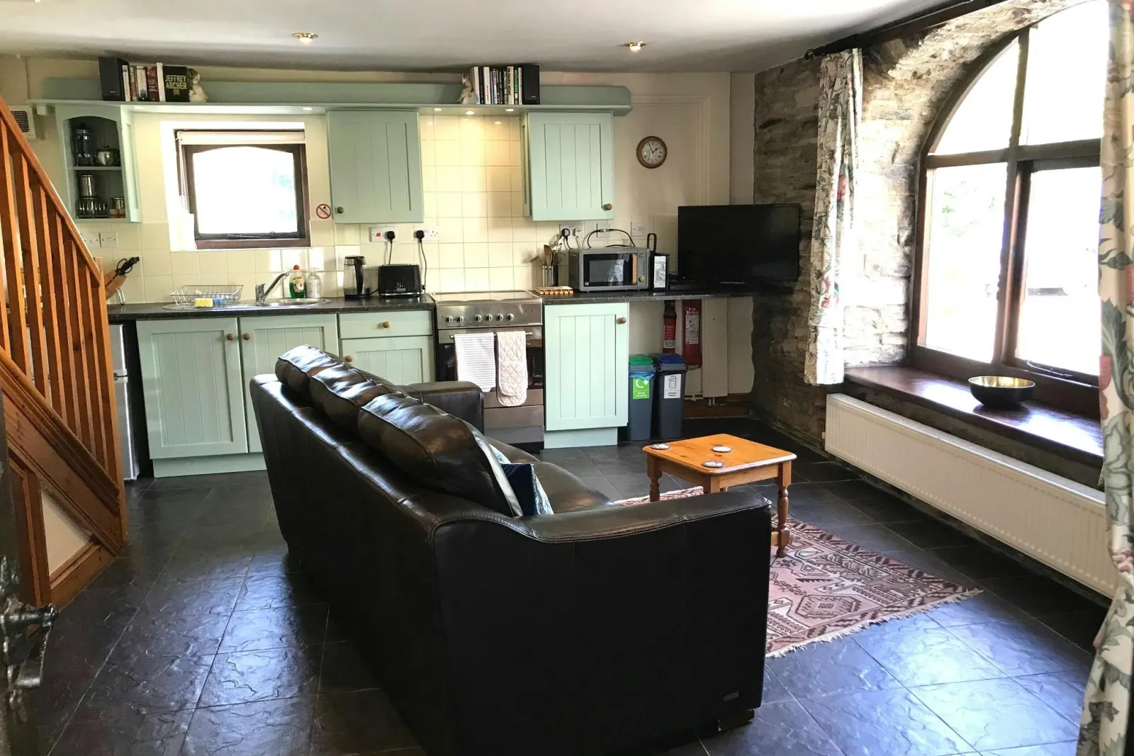 Open plan kitchen/diner: sofa, coffee table and TV; cooker, microwave, kettle and toaster