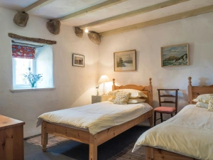 Twin single beds, bedside drawers with lamp and wooden chair