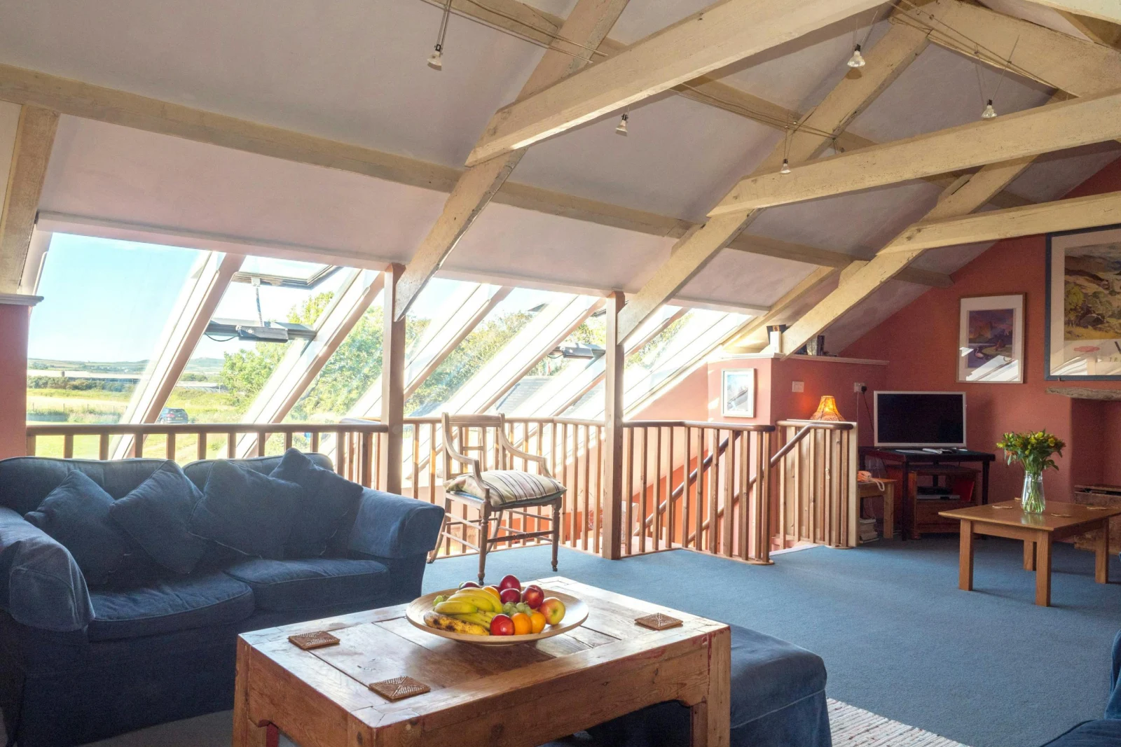 Lounge area with beamed ceiling, sofa, coffee table and TV