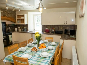 Fitted kitchen/dining area: range cooker, microwave, toaster, kettle, dining table with eight chairs
