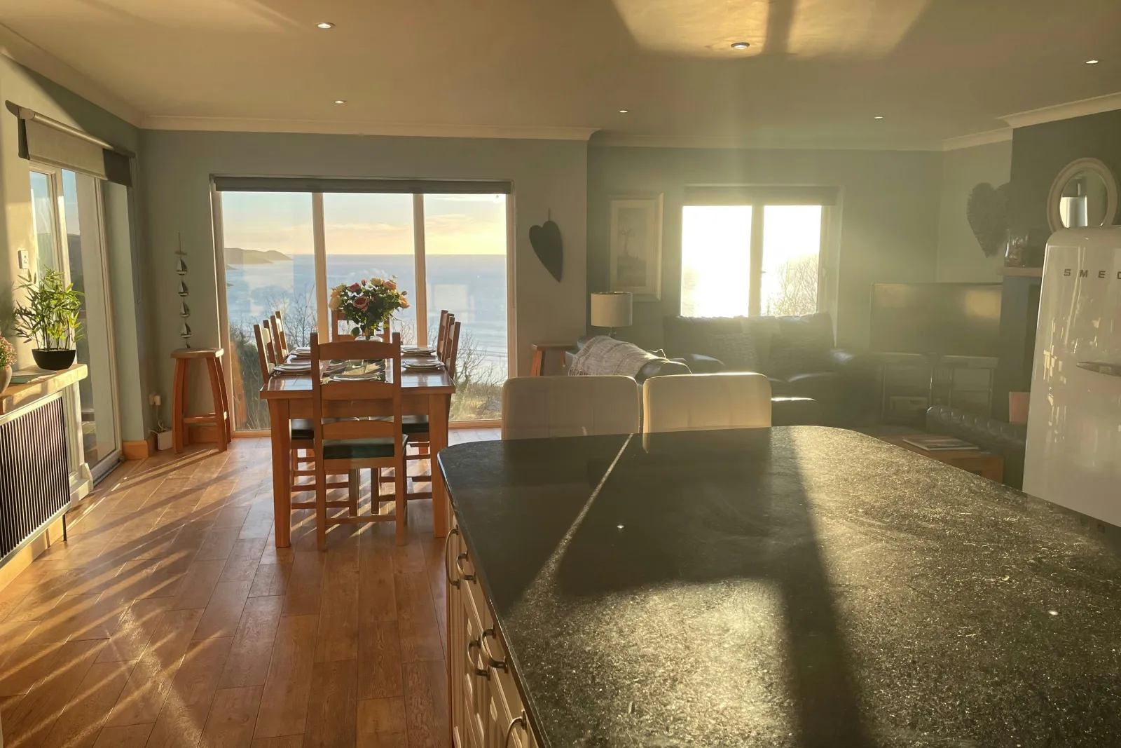 Open plan kitchen/dining/lounge area: patio doors with sea view