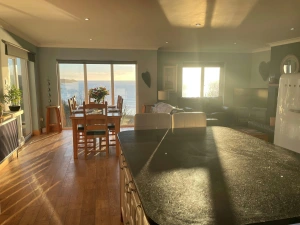 Open plan kitchen/dining/lounge area: patio doors with sea view