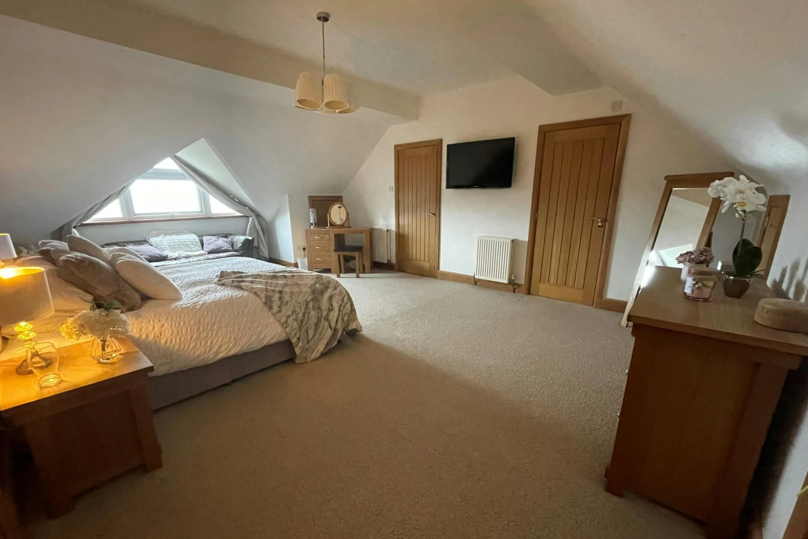 Bed, dressing table with stool, bedside cabinets with lamps, sofa under the window and chest of drawers