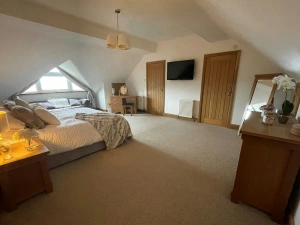 Bed, dressing table with stool, bedside cabinets with lamps, sofa under the window and chest of drawers