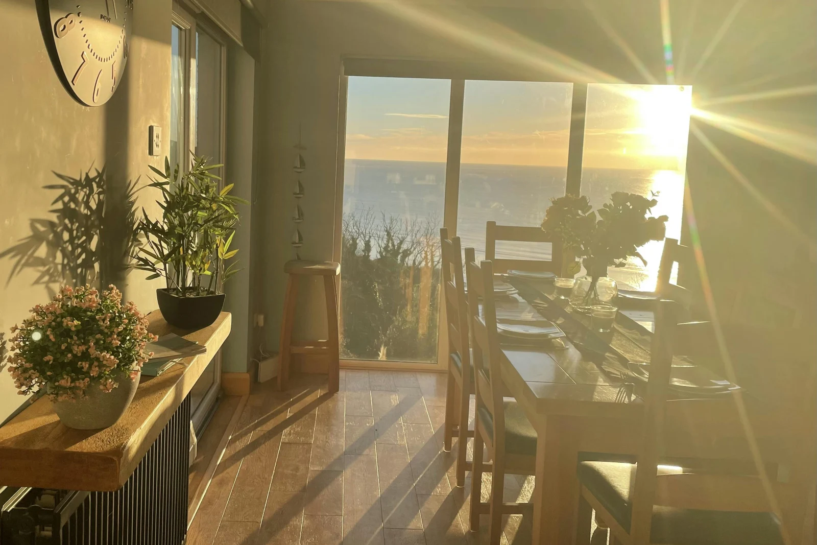 Dining table layered for breakfast, vase with fresh flowers, side table with flowers