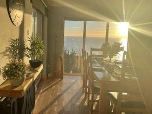 Dining table layered for breakfast, vase with fresh flowers, side table with flowers
