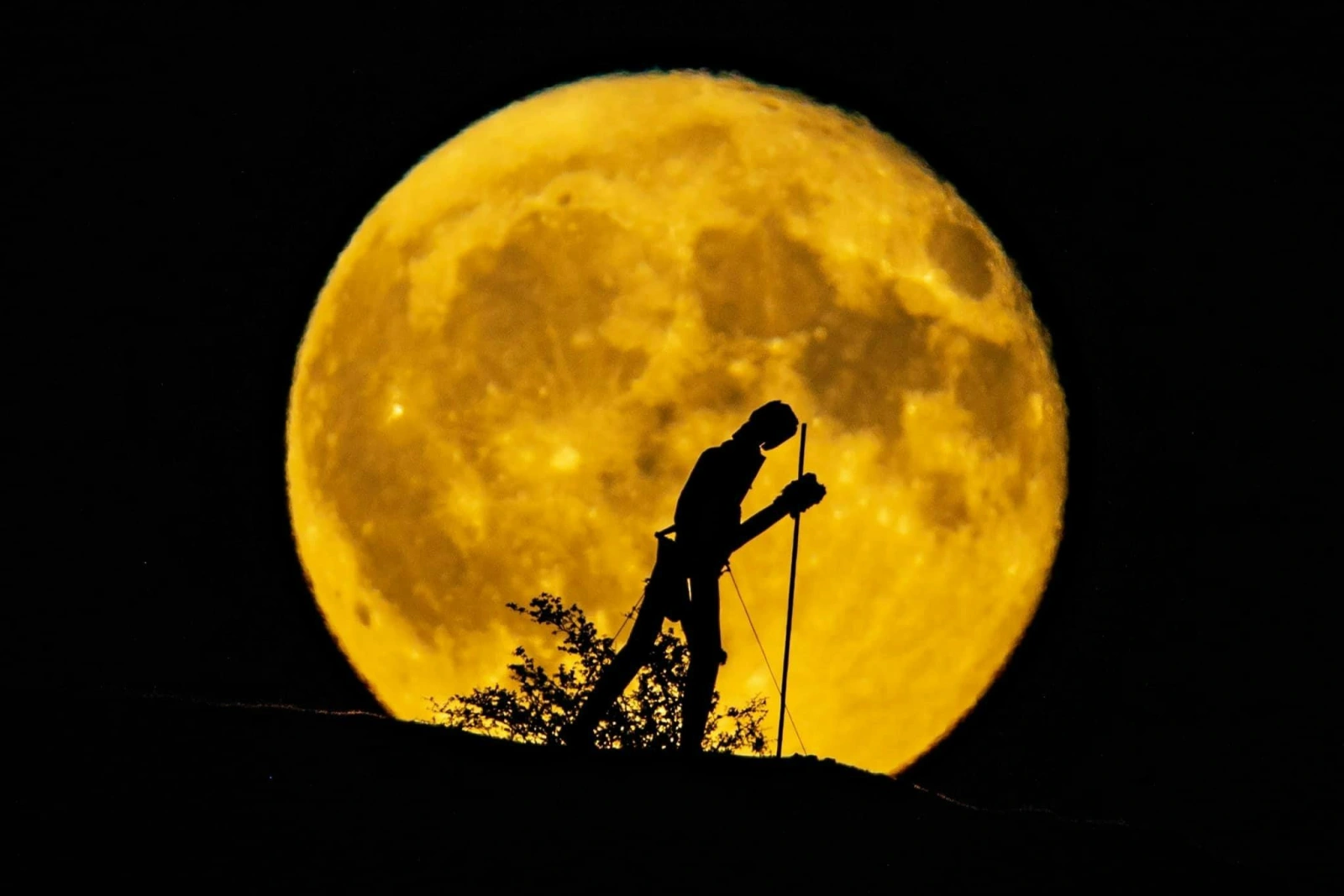 Statue of walking man against a full moon near Strata Florida