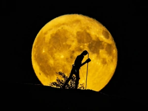 Statue of walking man against a full moon near Strata Florida