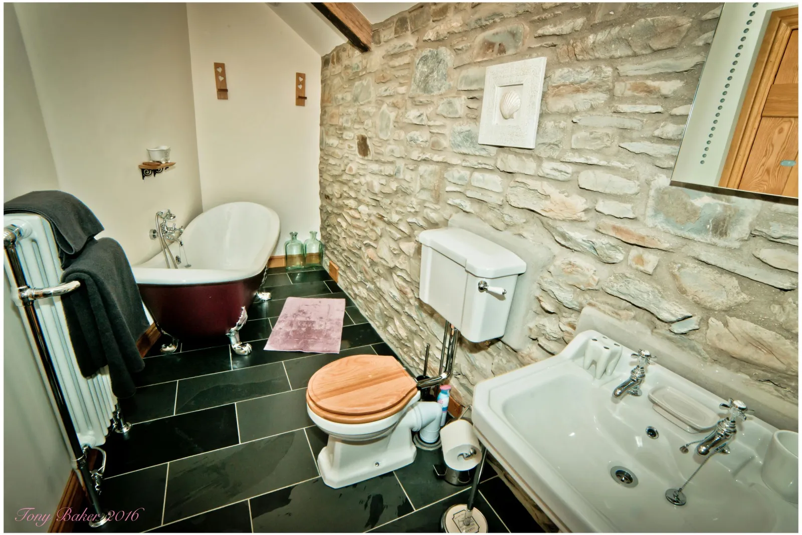 Bathroom with roll top bath, toilet and wash basin with mirror above