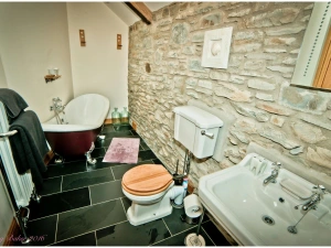 Bathroom with roll top bath, toilet and wash basin with mirror above