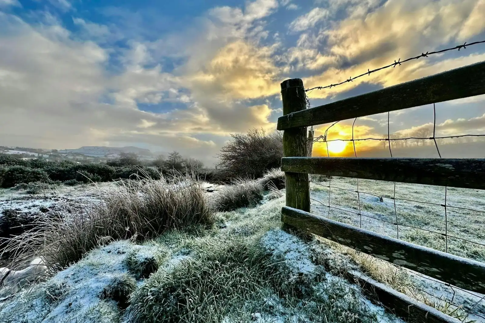 Countryside at sunset in winter, snow on the ground