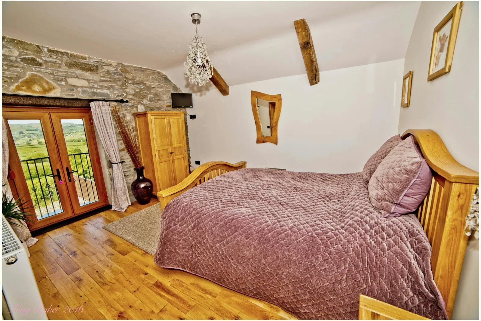 Bedroom with king size bed, bedside cabinet and wardrobe, double doors to balcony
