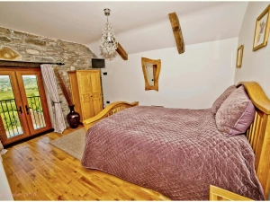 Bedroom with king size bed, bedside cabinet and wardrobe, double doors to balcony
