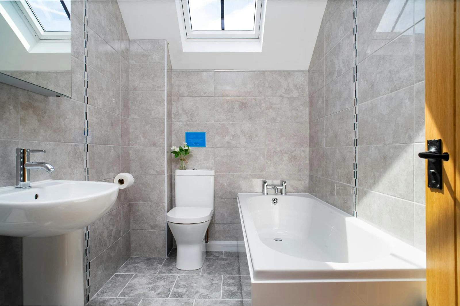 Tiled bathroom with bath, toliet, washbasin and velux windows