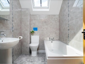 Tiled bathroom with bath, toliet, washbasin and velux windows