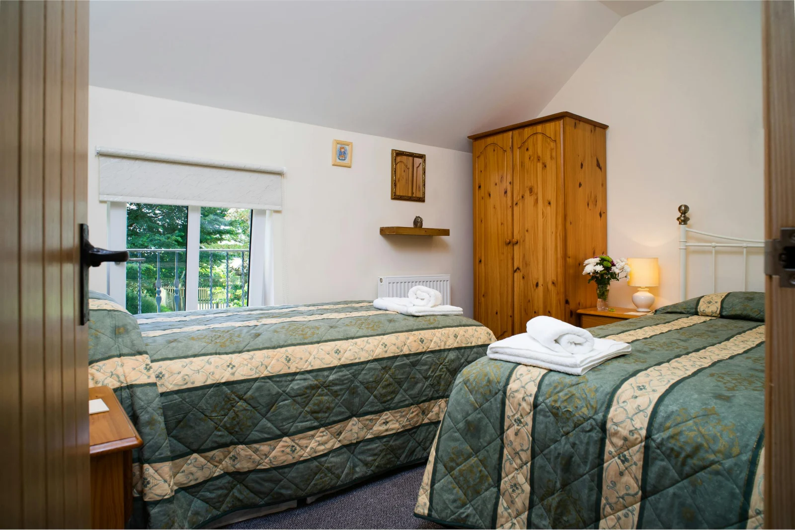 Twin single beds, wardrobe, bedside cabinets with lamps, radiator and window