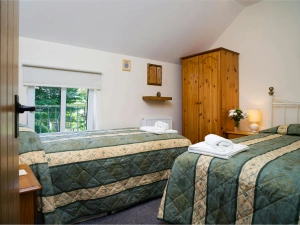 Twin single beds, wardrobe, bedside cabinets with lamps, radiator and window