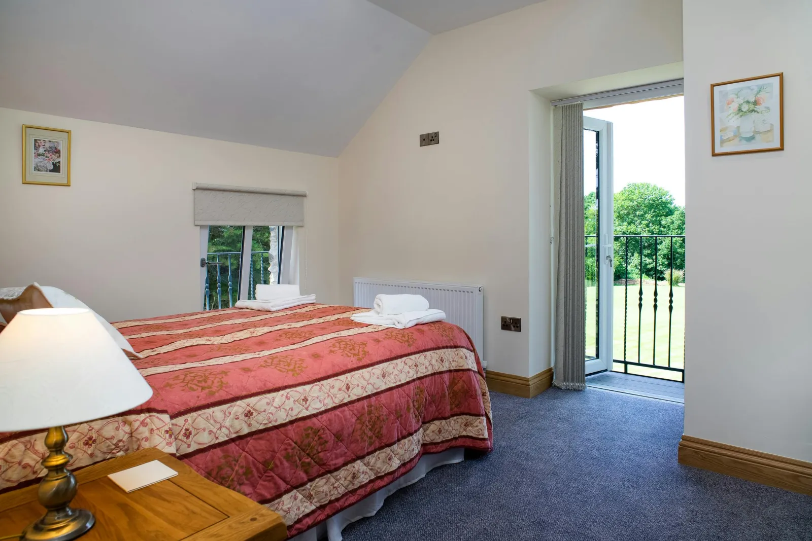 Double bed, bedside unit with lamp and doors to Juliet balcony