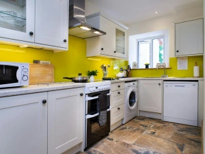 Fitted kitchen with cooker, washing machine, dishwasher, microwave, kettle and window