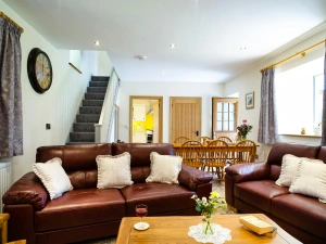 Sitting/dining room: leather sofas, coffee table, dining table and six chairs, stairs