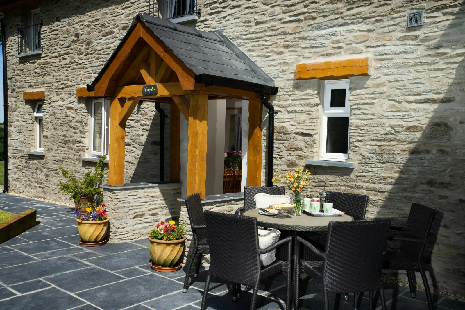 Front of Towy Cottage with paved patio, table and chairs