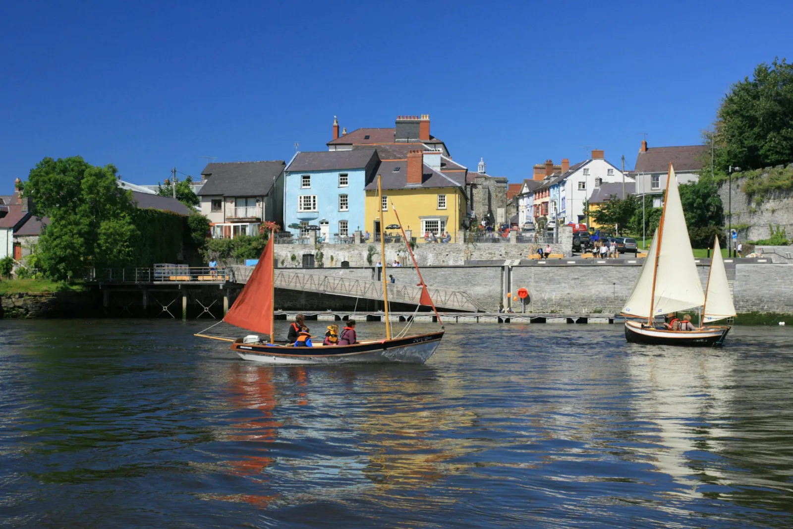 Boats and yachts on the river Teifi in Cardigan with shops and restaurants in the background