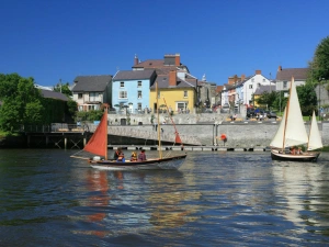 Boats and yachts on the river Teifi in Cardigan with shops and restaurants in the background