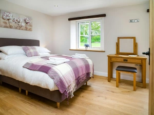 Bedroom with bed, dressing table, stool and mirror