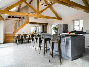 Kitchen and dining area at Towyn Farmhouse with beamed ceiling and stairs to first floor