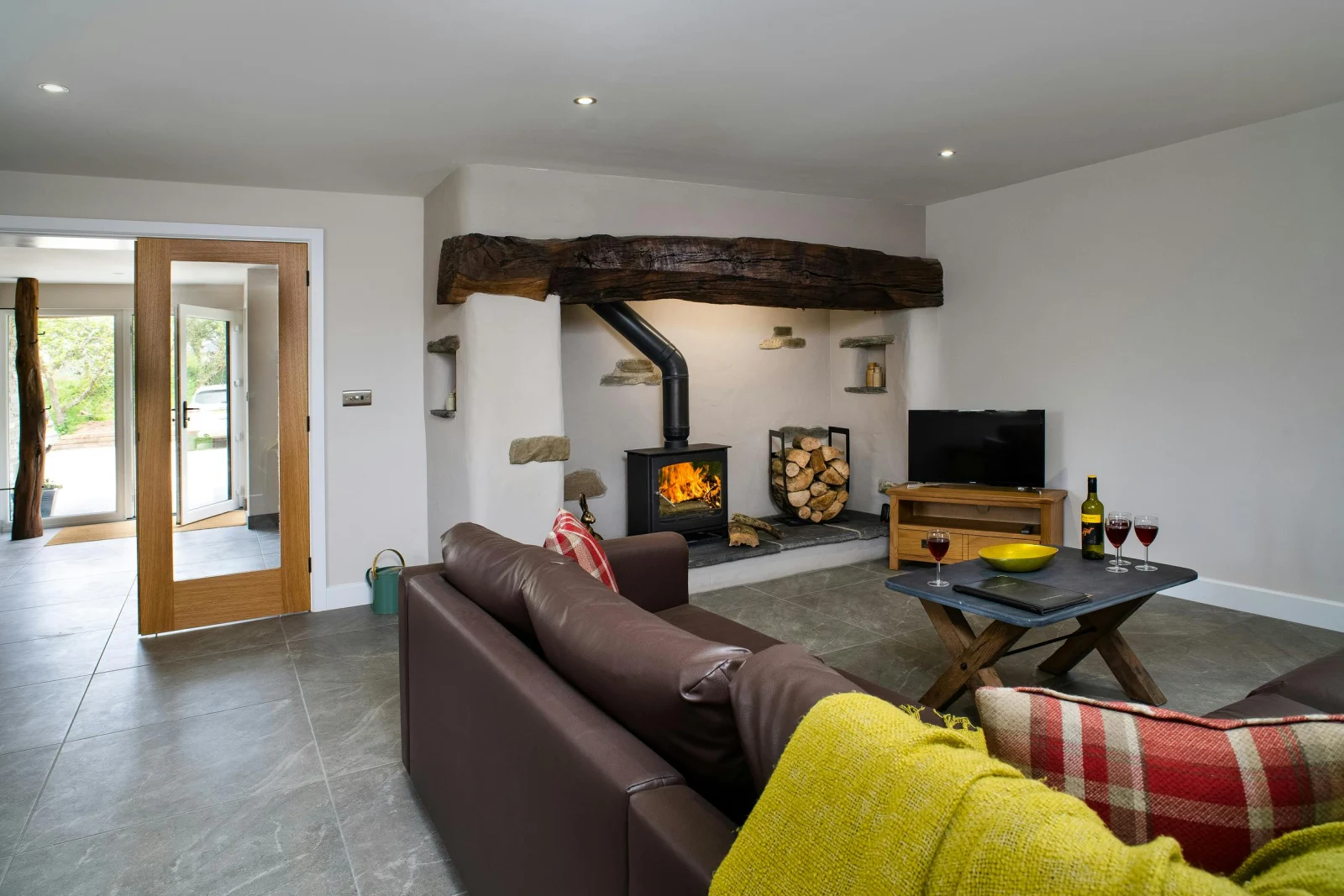 Living room with fireplace, log burner, sofa, TV on unit and coffee table