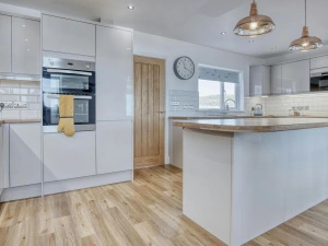 Island in the kitchen with work surfaces, kettle, microwave, built-in oven