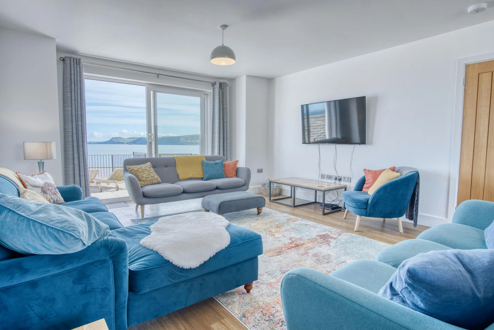 Sofas, coffee table, wall mounted TV, patio doors