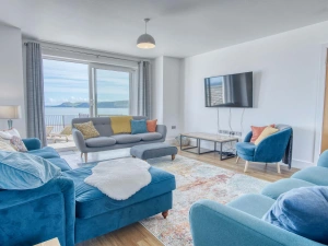 Sofas, coffee table, wall mounted TV, patio doors