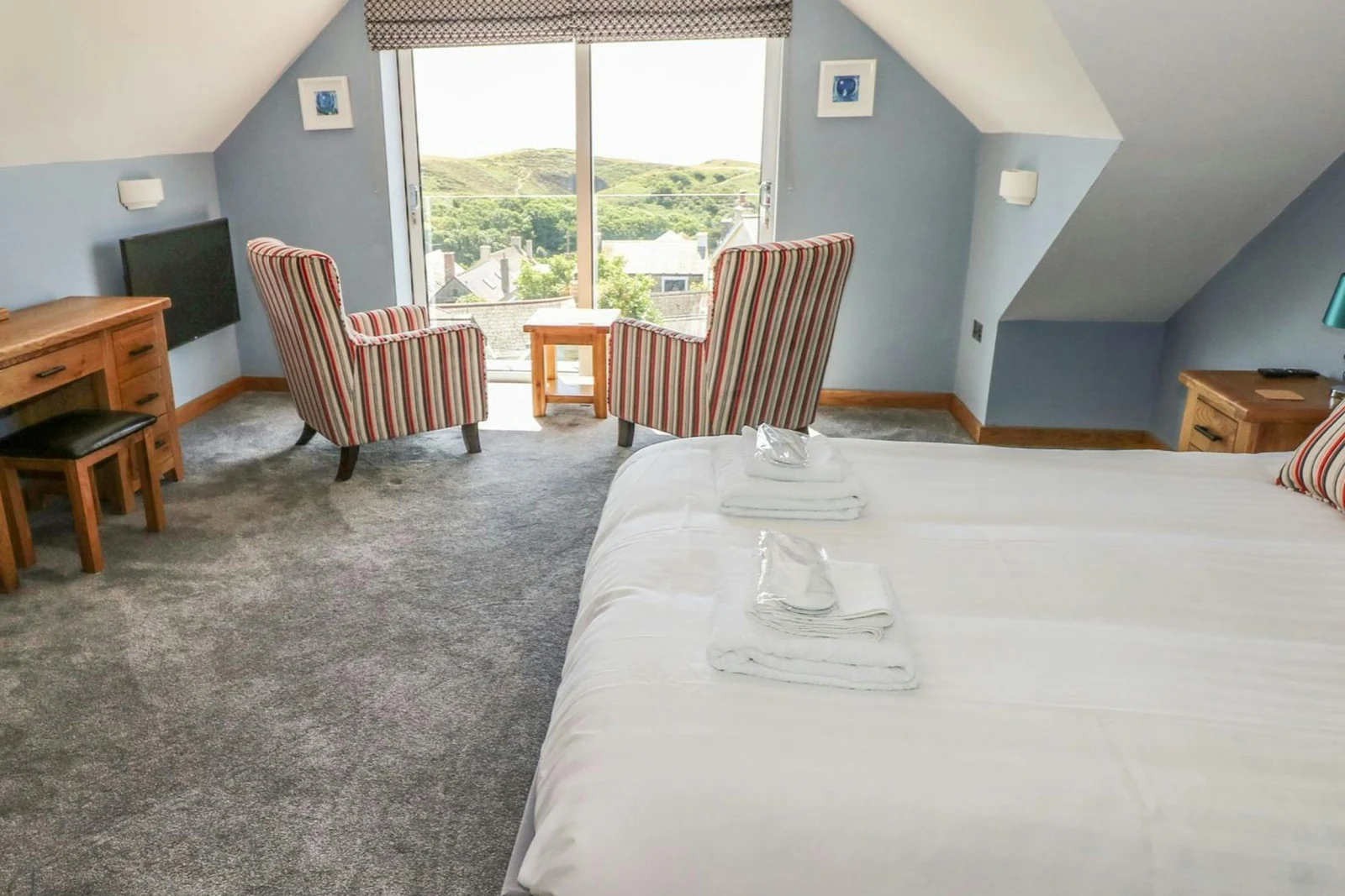 First floor king size bedroom with bed, 2 armchairs facing large window, TV, dressing table